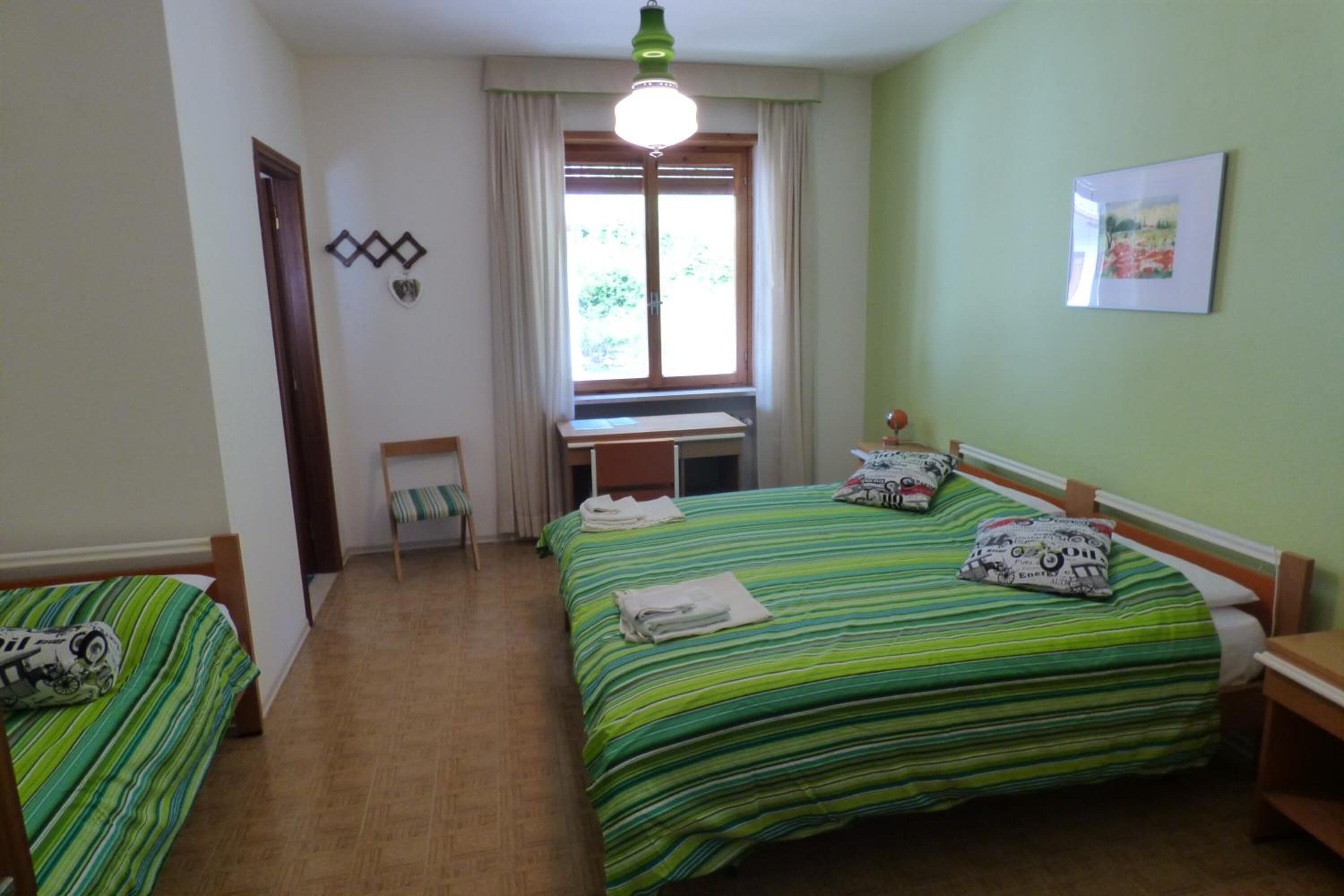 Une chambre avec deux lits, un bureau et une chaise.