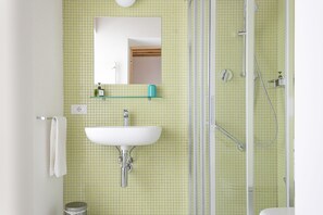 Habitació doble o amb dos llits individuals | Bany | Dutxa, capçal de dutxa tipus cascada, assecador de cabells i sabatilles 