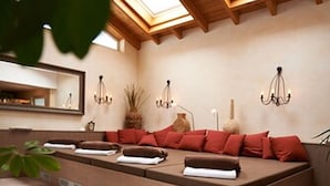Un cuarto de spa con un amplio espacio de descanso, tragaluces, un espejo y una planta pequeña.