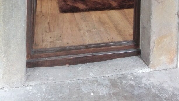 A bedroom with a bed, a wooden floor, and a stone wall. - Apartamentos Turísticos Los Picos (Liérganes)
