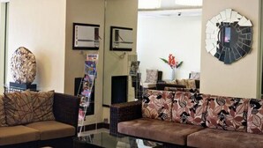 Una sala de estar con un sofá, una mesa de centro y un espejo decorativo.