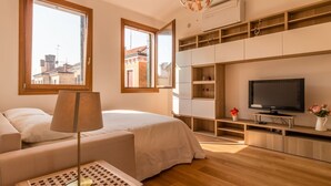 A modern bedroom with a bed, a TV, and built-in shelving.
