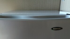 Ein kompakter, grauer Kühlschrank mit sichtbarem Markenlogo.