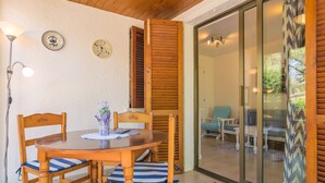 A wooden dining table with chairs, a lamp, and decorative plates on the wall. - ENCINAS 1 - Apartment with terrace in Port De Pollença. Free WiFi (Pollença)