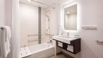 A modern bathroom with a bathtub, shower, and vanity.
