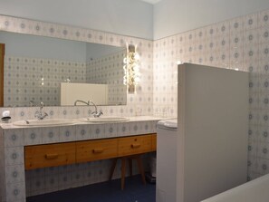 Kylpyhuone, jossa on kaksi pesuallasta, peili ja wc.