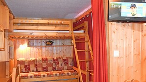 Habitación con literas y televisión en la pared.
