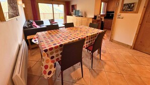 Ein Essbereich mit einem Tisch, der mit einer tischdecke mit Punkten bedeckt ist, umgeben von Stühlen.