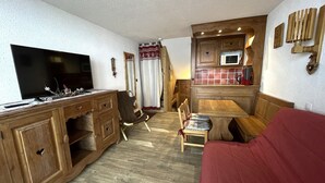 A compact living space with a kitchenette, a dining area, and a seating area.