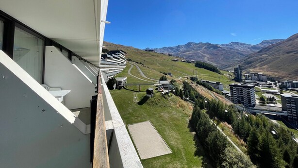 Un bâtiment moderne doté d’un balcon donnant sur un paysage montagneux.
