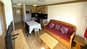 A compact living space with a kitchenette, a dining area, and a sofa.