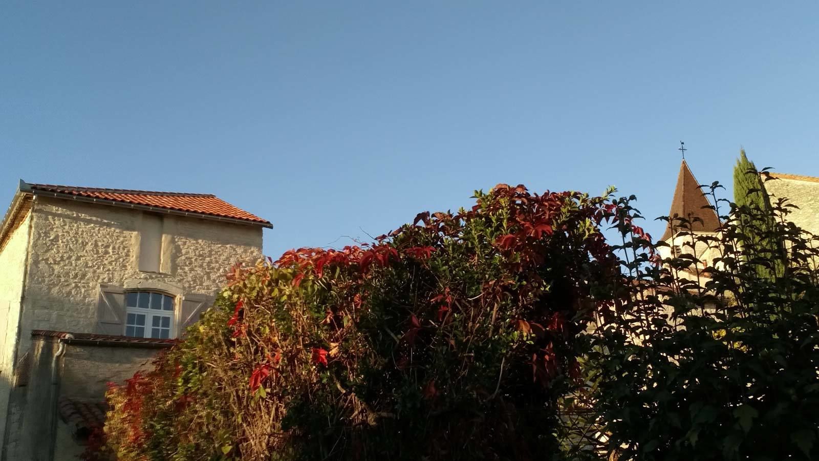 Un edificio de piedra con techo de tejas rojas y una pequeña ventana.