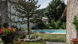 Un sendero de piedra que conduce a una zona de piscina con vistas a una montaña y un cielo despejado.