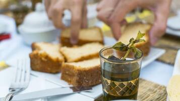 A dining table with slices of bread, a glass of iced tea, and a fork.
