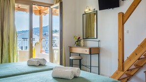 Una habitación de hotel con cama, escritorio, espejo y televisor.