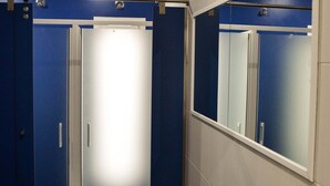 A narrow, enclosed elevator with blue walls and a white door. - Albergue Alfonso II el Casto - Hostel (Melide)