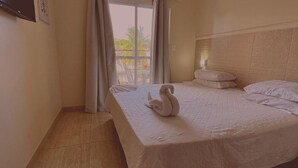A hotel room with a large bed, a headboard, and a window with curtains. - Pousada Espaço Viana (Ipojuca)