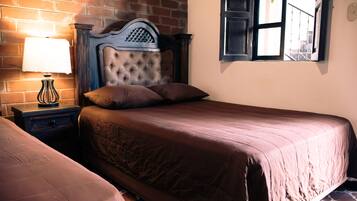 A bedroom with a bed, a nightstand, a lamp, and a window with a view.