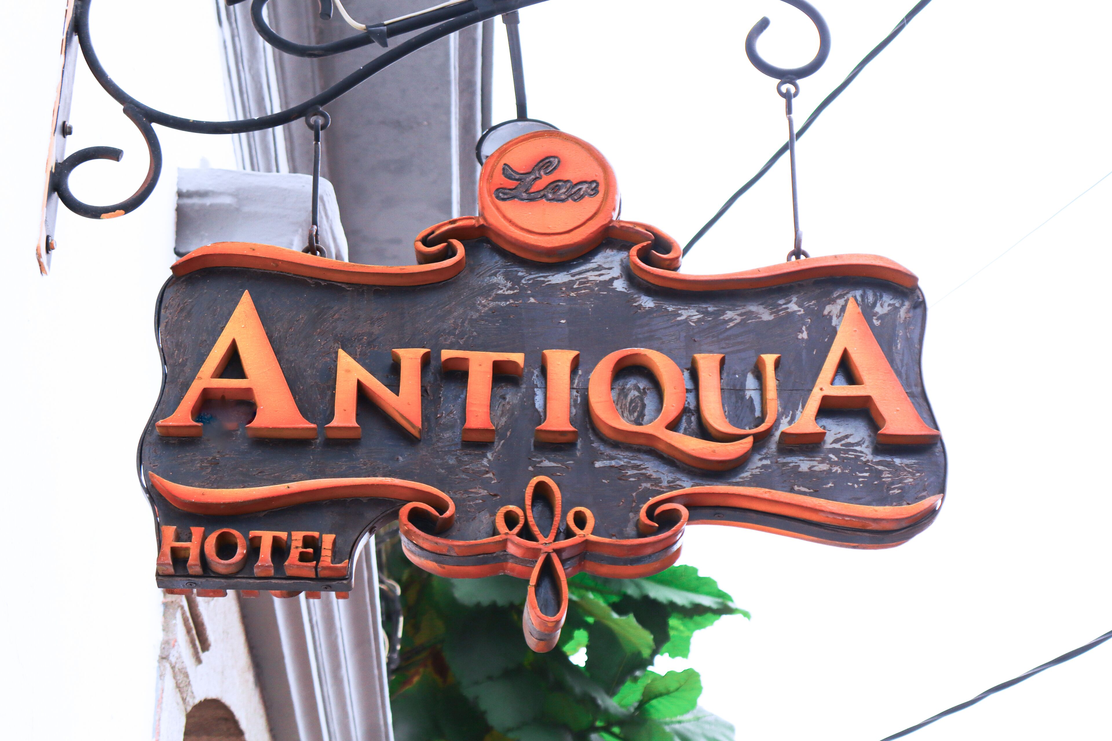A wooden sign with the words "ANTIQUE HOTEL" and a logo above it.