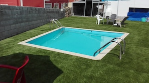 Utomhuspool, parasoller och solstolar