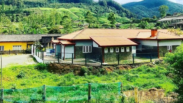 A rural village with traditional houses, a clear sky, and lush green hills in the background. - Casablanka Rest (Nanuoya)