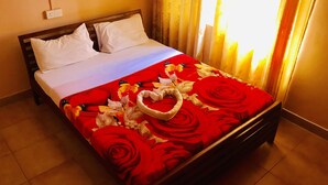 A bed with a floral bedspread, white pillows, and a heart-shaped decoration on the bed. - Casablanka Rest (Nanuoya)