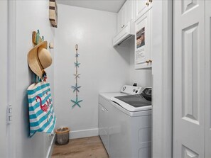 A laundry room with a washing machine, a drying rack, and a wall-mounted star decoration. - Waterfront 3BR, heated pool, WiFi, and serene Mid-Island views. (Marco Island)