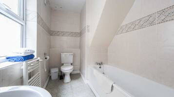 Bathtub, hair dryer, towels, toilet paper