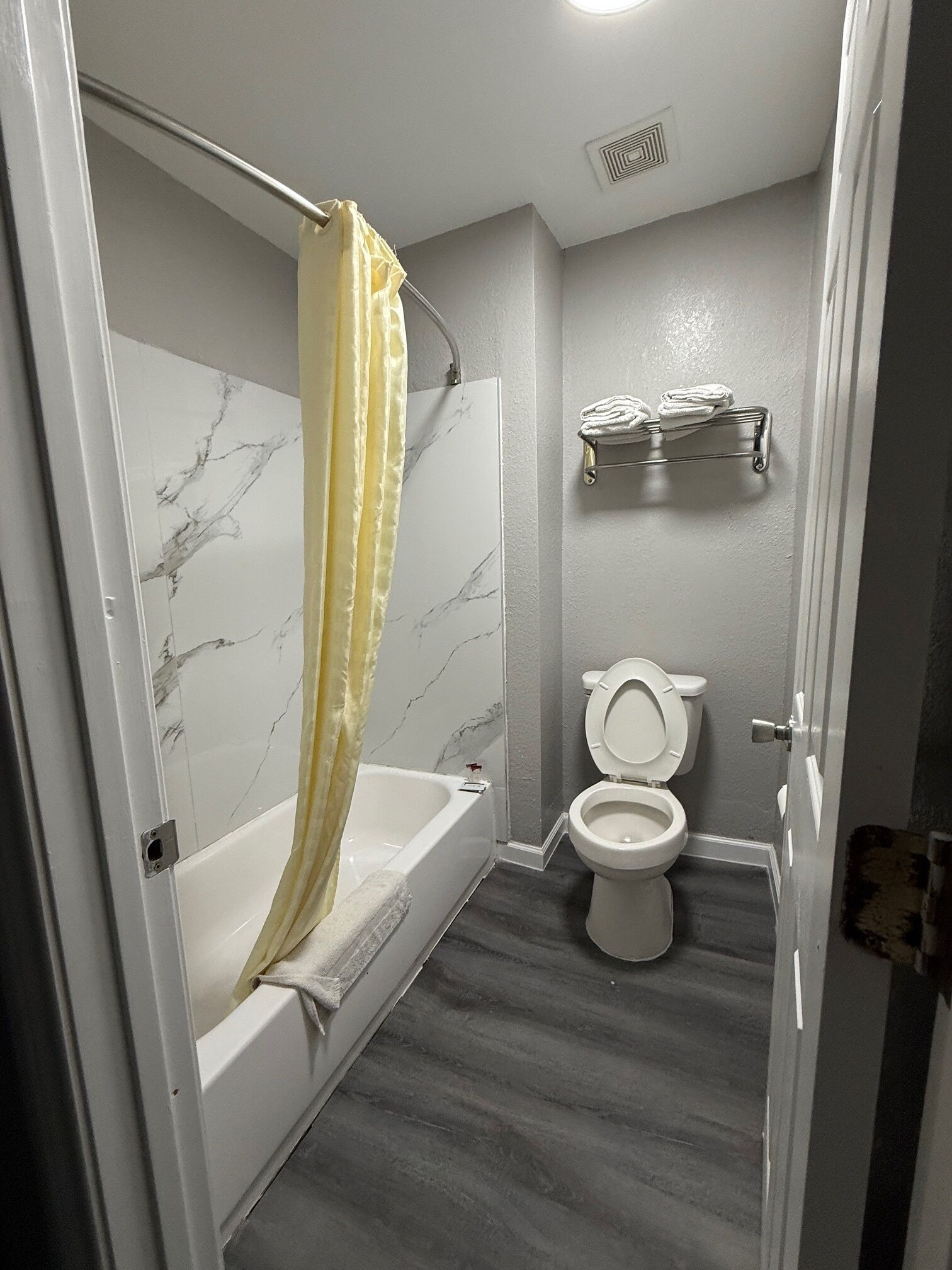 Un baño con bañera, inodoro y toallero.