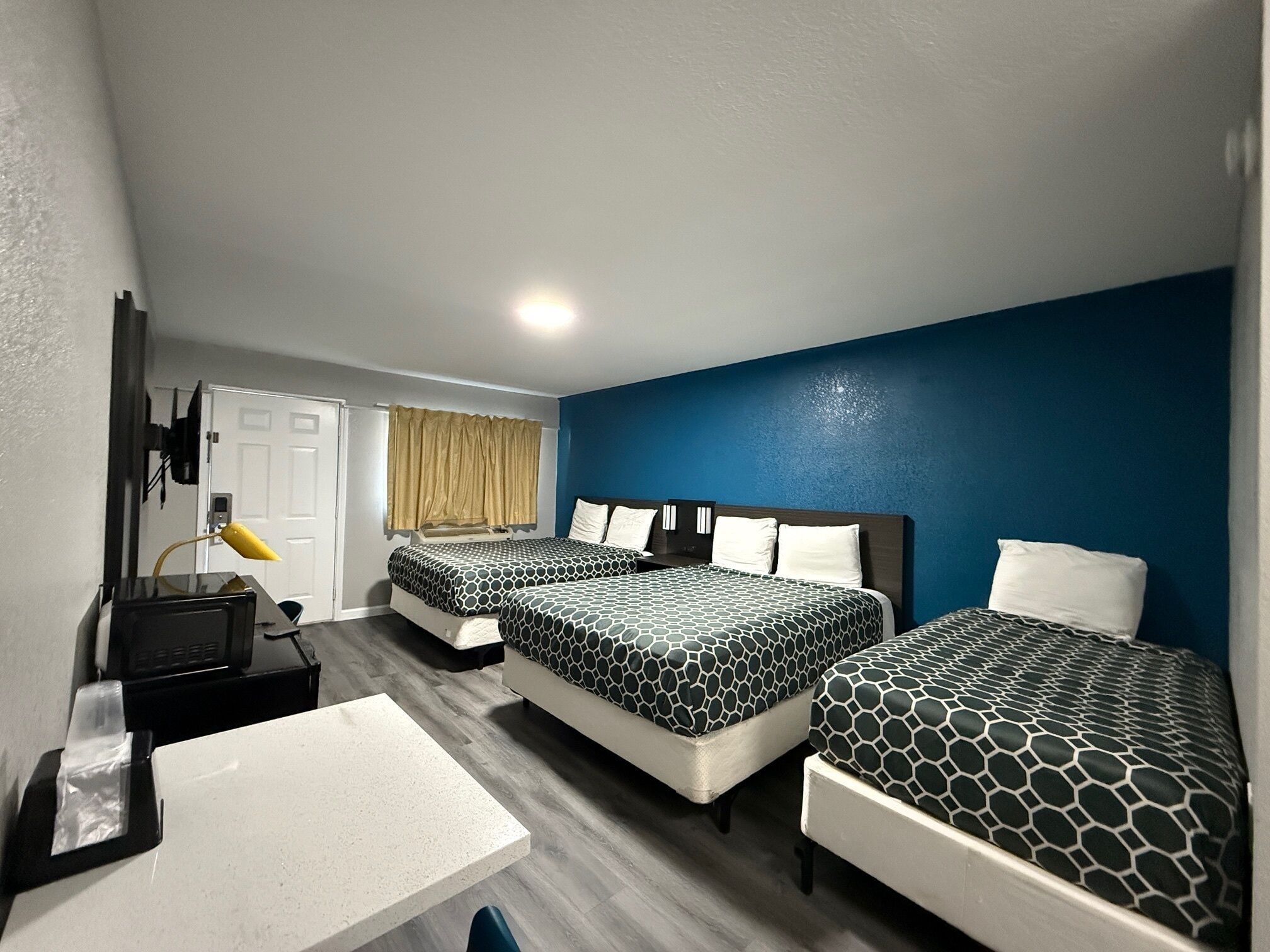 Habitación de hotel con dos camas, un escritorio y una silla.