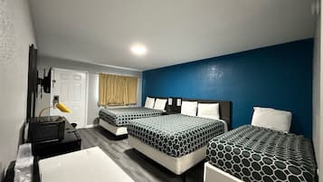 Habitación de hotel con dos camas, un escritorio y una silla.