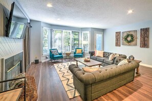 Relax in this stylish living room with a large sectional sofa, armchairs, and a coffee table.