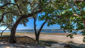A stone bench with a view of a beach and a body of water. - LOCATION!!  Lake Travis Waterfront~Pool, Spa, Outdoor Kitchen, Location (Austin)