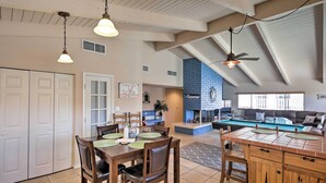 Amplia sala de estar con una mesa de comedor, sillas, chimenea y sofá.