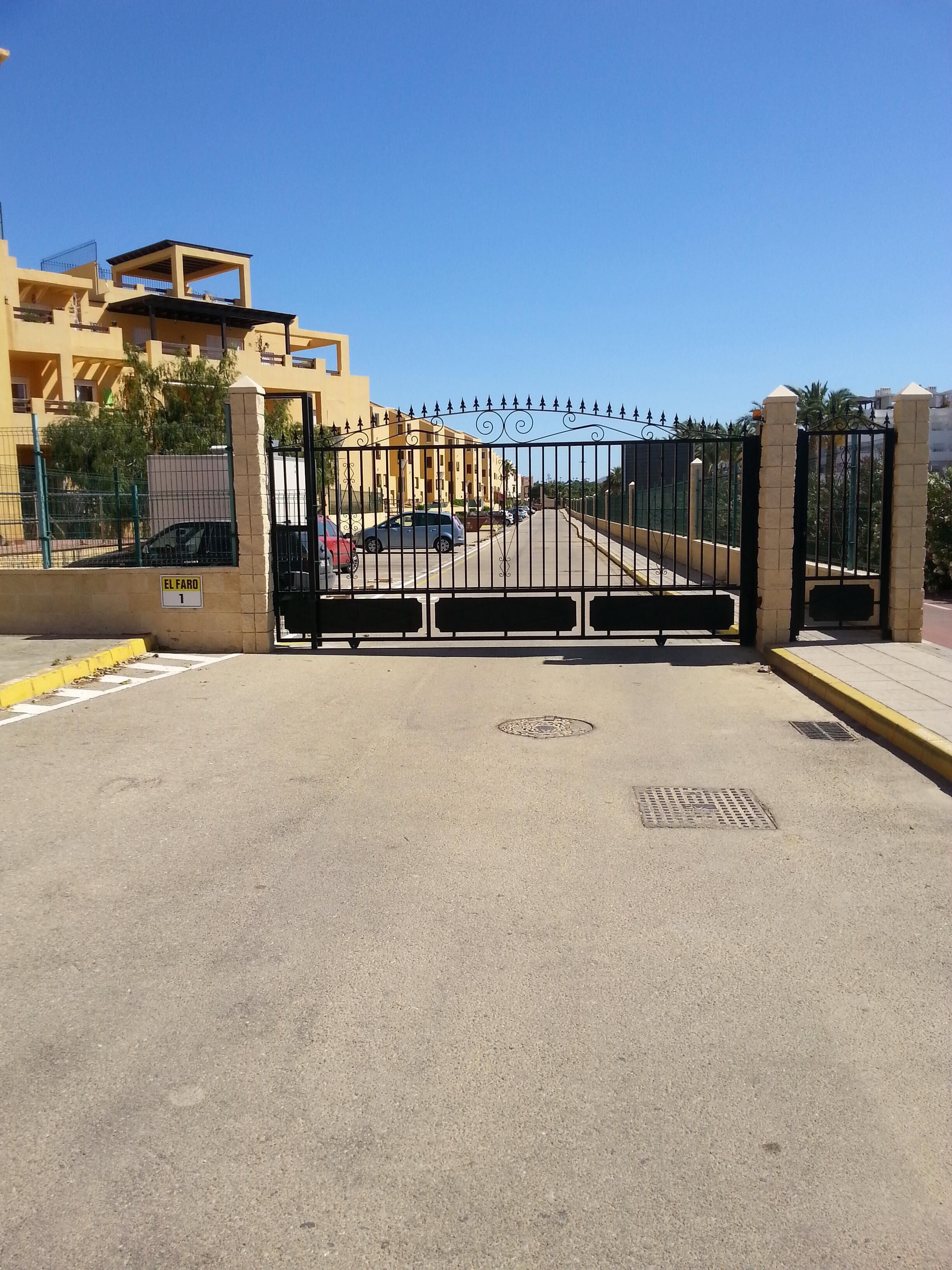 A gated entrance with a clear pathway leading to a building.