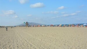 A sandy beach with a lifeguard tower, umbrellas, and people. - House (triplex) in Puerto Rey, Vera Playa, Almeria, 400m from beach (Puerto Rey, Vera Playa)