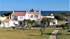 A white building with a red-tiled roof, a satellite dish, and a view of the sea. - Charming villa, beautiful sea view. Swimming pools. Sand beach. Very calm. (Porches)