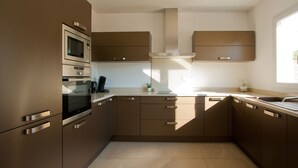 Una cucina moderna con elettrodomestici integrati, un'ampia finestra e un design pulito e minimalista.