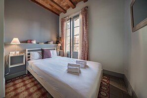 A bedroom with a bed, bedside tables, a lamp, and a window with curtains. - Alaia 21 - Habitat Apartments (Barcelona)