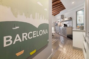 A modern kitchen with a cityscape mural, a dining area, and a patterned floor. - Alaia 21 - Habitat Apartments (Barcelona)