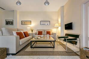 Ein modernes Wohnzimmer mit einer Couch, einem Couchtisch, einer Lampe und einem Sessel.