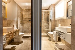 A modern bathroom with a glass shower enclosure, a separate toilet, and a vanity with a sink.