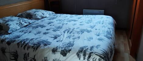 Ein Schlafzimmer mit einem Bett, einem Sessel und einem Fenster.