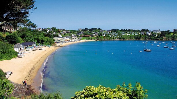 A coastal town with a sandy beach, clear blue waters, and boats. - Longere with seaside view (Cancale)