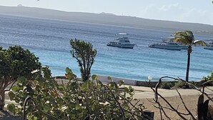A coastal view with military ships, a clear sky, and a distant landmass. - Oceanfront Completely Upgraded Sand Dollar Resort  1 Bedroom Unit A2. Bari Reef (Bonaire)