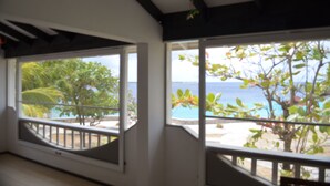 A room with large windows overlooking a beach and ocean. - Oceanfront Completely Upgraded Sand Dollar Resort  1 Bedroom Unit A2. Bari Reef (Bonaire)