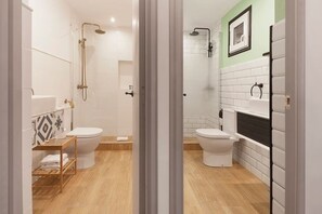 A modern bathroom with two toilets, a shower area, and a vanity with a sink.
