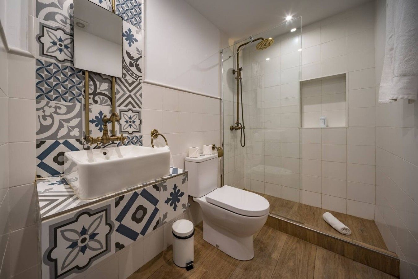 A bathroom with a white sink, toilet, and shower.