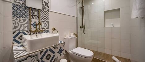 A bathroom with a white sink, toilet, and shower.