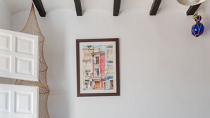 A living room with a gray sofa, a patterned rug, a framed artwork, and a white door. - Charming apartment, first line of the Center Beach, Villajoyosa (Villajoyosa)